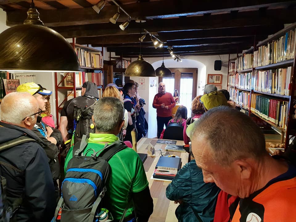 Los senderistas de Ubrique atienden las explicaciones del historiador Fernando Sígler en la biblioteca de la Casa de la Memoria.