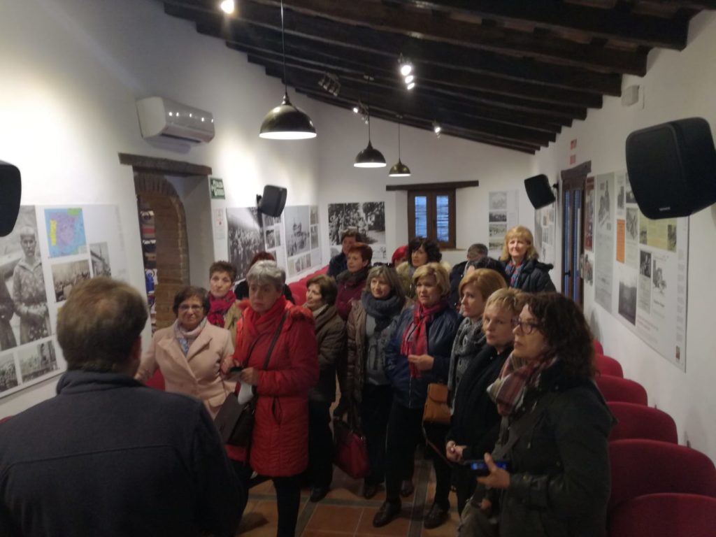 Integrantes de las asociaciones de mujeres de Jaén atienden las explicaciones de Andrés REbolledo en la exposición sobre el exilio de la Casa de la Memoria.