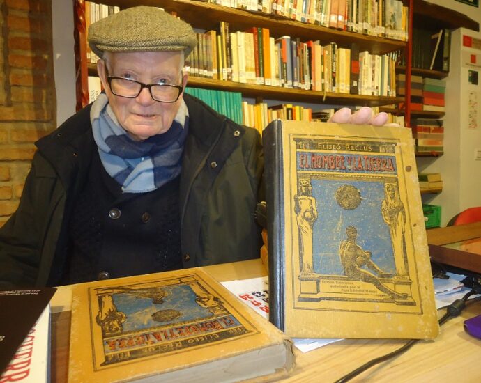 José Netto, con la enciclopedia de Reclus, en la Biblioteca de la Casa de la Memoria.